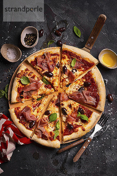 Pizza mit Mozzarella  Parmaschinken  Oliven und Basilikum