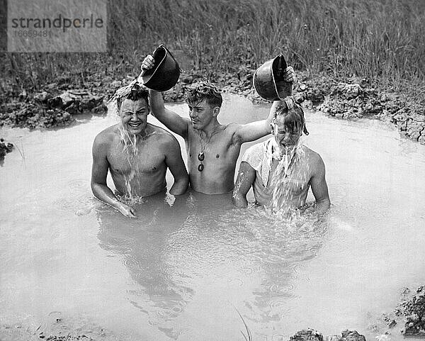 Okinawa  Japan: Juni  1945
Drei Panzersoldaten der Sechsten Marinedivision erfrischen sich nach einer langen Tour in ihrem Panzer im kühlen Wasser einer Granatenwanne.