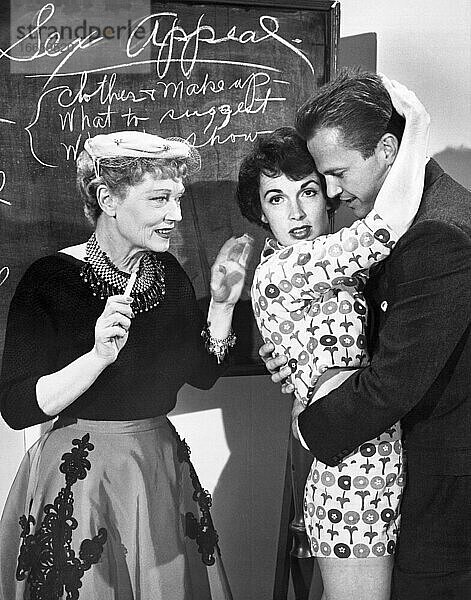 Hollywood  Kalifornien  3. Dezember 1954.
Gilda Gray  die Ziegfeld-Shimmy-Königin der wilden Zwanziger  wurde engagiert  um vier schwülen Sirenen beizubringen  wie man sich für den Film Kiss Me Deadlly   einen Mickey-Spillane-Thriller  sexy verhält. Hier zeigt sie der Schauspielerin Maxine Cooper  wie man Ralph Meeker im Film umarmt.