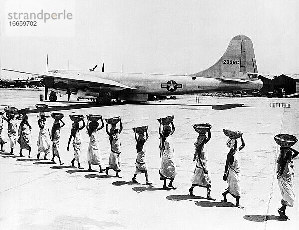 Indien  17. Juni 1944 Indische Frauen arbeiten an der Vergrößerung des örtlichen Flughafens  während eine B-29 der US-Armee für einen Bombenangriff auf Japan fertig gemacht wird.