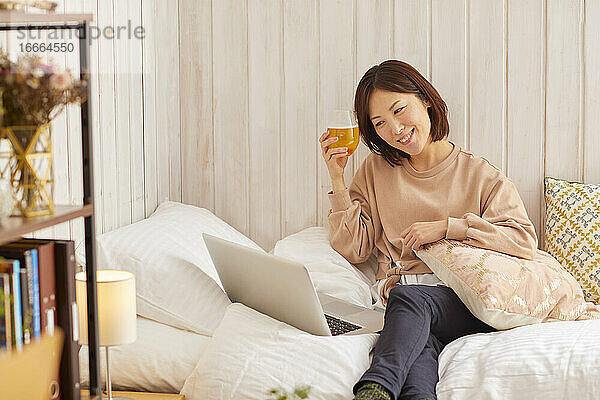 Japanische Frau  die zu Hause trinkt  trinkt aus der Ferne