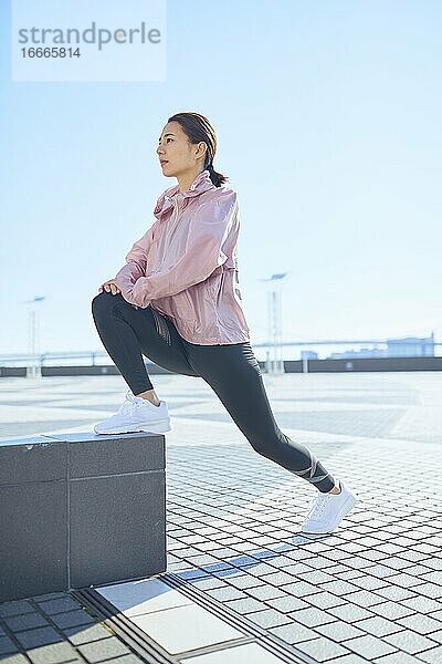 Junge japanische Frau beim Stretching in der Innenstadt von Tokio  Japan