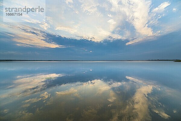 Wolken spiegeln sich bei Sonnenaufgang auf dem glatten See  Filsø  Henne Strand  Jütland  Dänemark  Europa