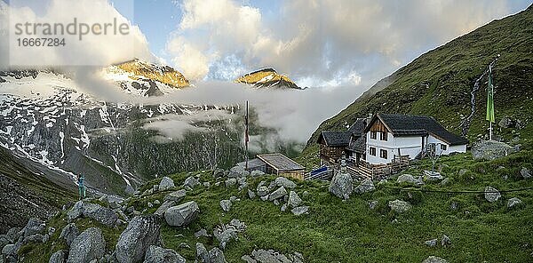 Wanderin blickt auf Berggipfel mit letztem Sonnenlicht  Furtschaglhaus  Berglandschaft mit Wolken  Berliner Höhenweg  Zillertaler Alpen  Zillertal  Tirol  Österreich  Europa