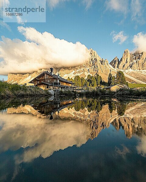 Spiegelung von dem Furchetta Berg und der Geisler Alm Hütte in einem Tümpel bei der Geisler Alm zum Sonnenuntergang  Sankt Magdalena  Südtirol  Italien  Europa
