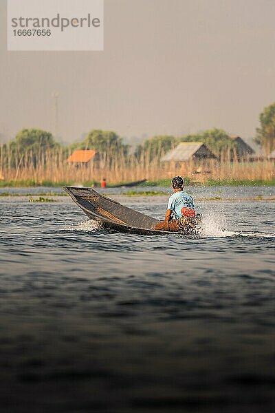 Fischer fährt mit seinem Boot auf dem Lake Inle  Myanmar  Asien