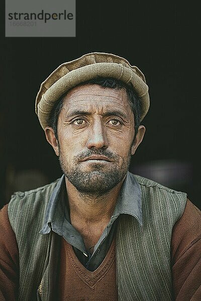 Ahmed  Lastenträger der ethnischen Gruppe der Wakhi  Blick in die Kamera  vor schwarzem Hintergrund  Wakhan-Korridor  Saradh-e-Broghil  Afghanistan  Asien