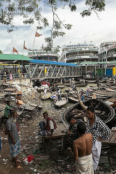 Vier Männer im Gespräch  Hafen  dahinter Flussfähren und kleine Boote  Dhaka  Bangladesch  Asien