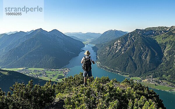 Wanderer blickt in die Ferne  Ausblick vom Bärenkopf auf den Achensee  links Seekarspitze und Seebergspitze  rechts Rofangebirge  Karwendel  Achensee  Tirol  Österreich  Europa