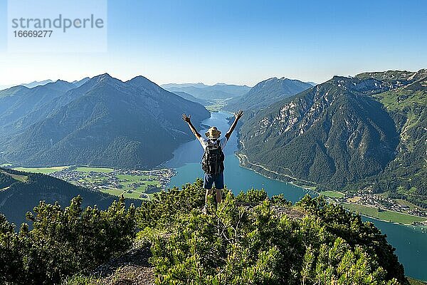 Wanderer streckt Arme in die Luft  Ausblick vom Bärenkopf auf den Achensee  links Seekarspitze und Seebergspitze  rechts Rofangebirge  Karwendel  Achensee  Tirol  Österreich  Europa