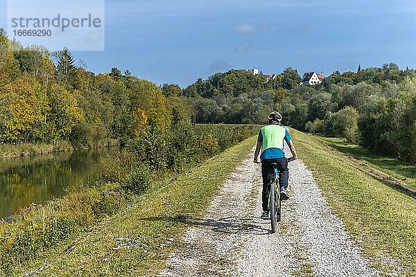 Farhrradfahrer auf Fahrradweg auf dem Kanaldamm der Isar  Farhrradfahrer auf Fahrradweg auf dem Kanaldamm der Isar  hinten Grünwalder Burg  Grünwald  Oberbayern  Bayern  Deutschland  Europa