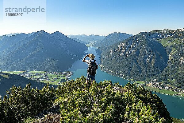 Wanderer blickt in die Ferne  Ausblick vom Bärenkopf auf den Achensee  links Seekarspitze und Seebergspitze  rechts Rofangebirge  Karwendel  Achensee  Tirol  Österreich  Europa