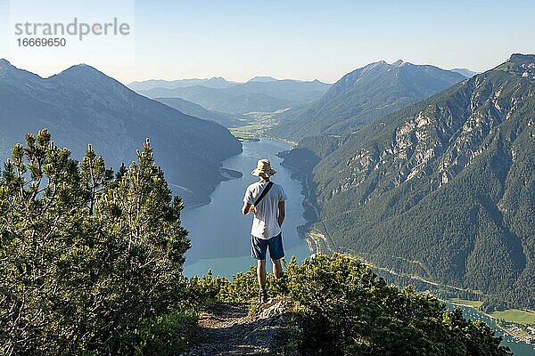 Wanderer blickt in die Ferne  Ausblick vom Bärenkopf auf den Achensee  links Seekarspitze und Seebergspitze  rechts Rofangebirge  Karwendel  Achensee  Tirol  Österreich  Europa