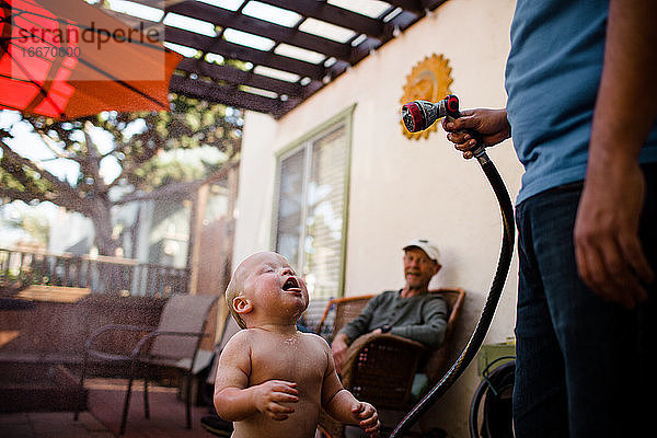 Onkel besprüht Neffe mit Schlauch  während Opa in San Diego lächelt