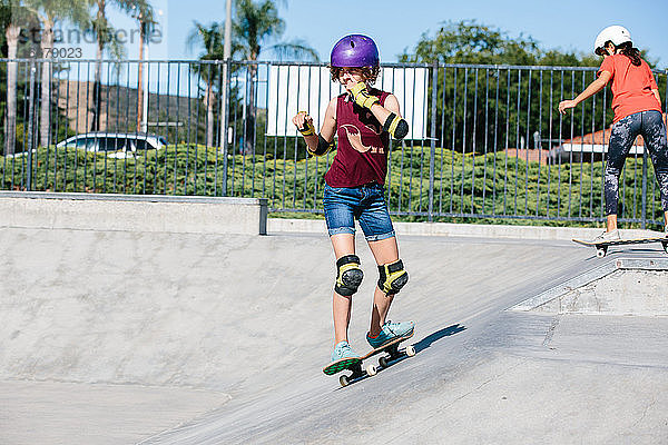 Teenager-Mädchen skatet in einem Skatepark und zerkratzt sich dabei das Gesicht