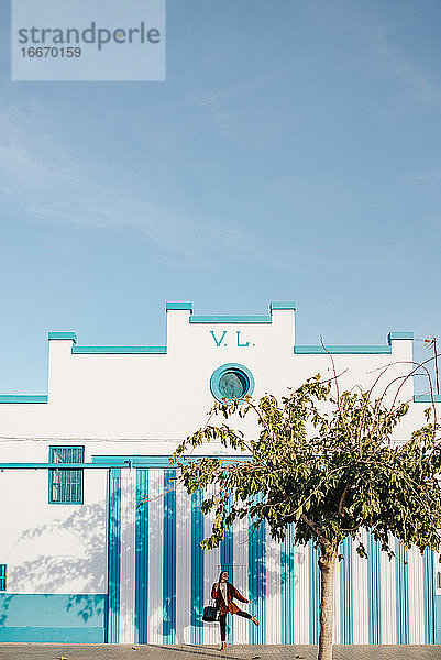 Fröhliches Mädchen tanzt vor dem Gebäude eines Fischers in Valencia