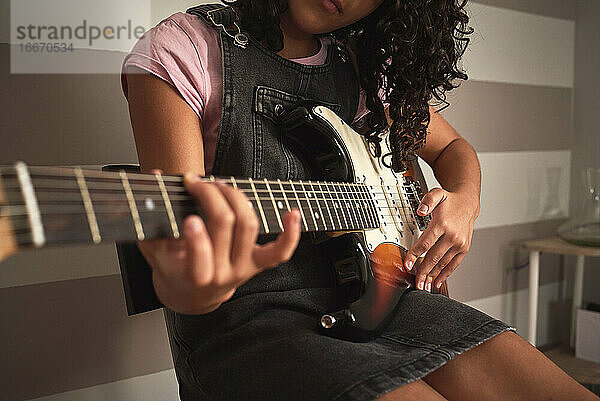 Nahaufnahme eines Mädchens beim Spielen der E-Gitarre