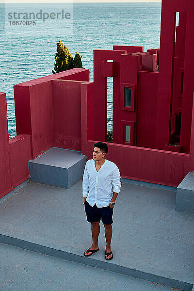 Junger lateinamerikanischer Mann meditativ in 'Muralla Roja' aus Calpe  Spanien