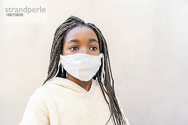 schönes afrikanisches Mädchen posiert mit ihrer Maske