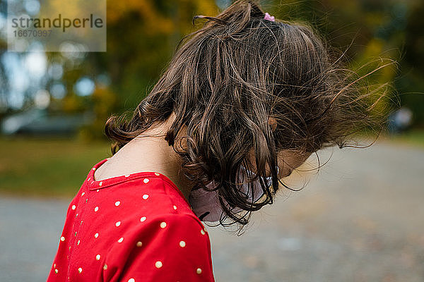 Drei Jahre altes gemischtrassiges Mädchen mit Gesichtsmaske im Freien Herbst Porträt
