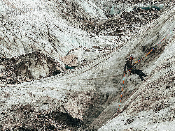 Nahaufnahme eines Bergsteigers beim Abseilen auf einem Gletscher in den europäischen Alpen