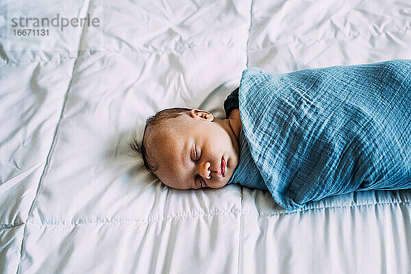 Überkopf des neugeborenen Babys  das auf einer weißen Decke schläft
