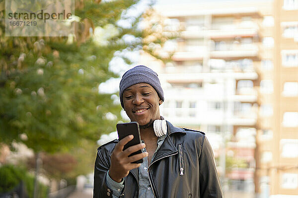 glücklicher junger afrikanischer Mann in der Stadt  der Musik hört