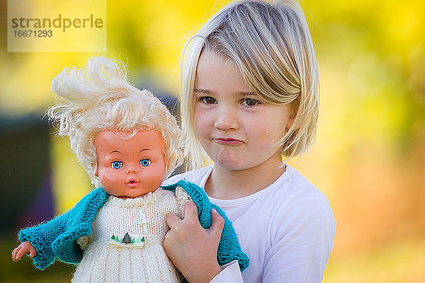 Junges Mädchen mit Oldtimer-Puppe