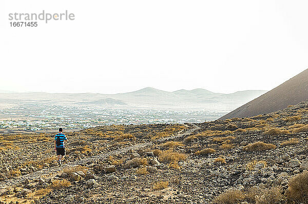 Mann wandert durch die Berg- und Wüstenlandschaft von Fuerteventura