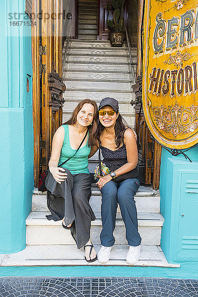 zwei Freundinnen sitzen am Eingang eines Hauses in Buenos Aires