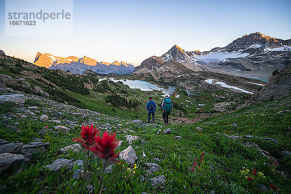 Ehepaar wandert gemeinsam bei Sonnenuntergang in den Rocky Mountains