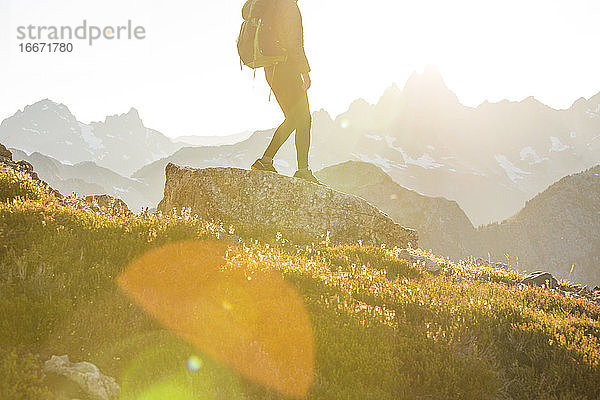 Untere Hälfte eines Rucksacktouristen auf einem Bergkamm