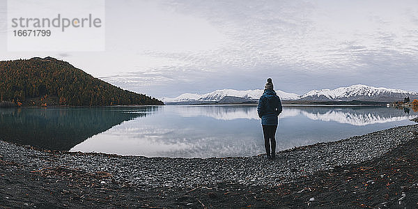 Junge Frau steht vor dem Lake Tekapo und den Südalpen