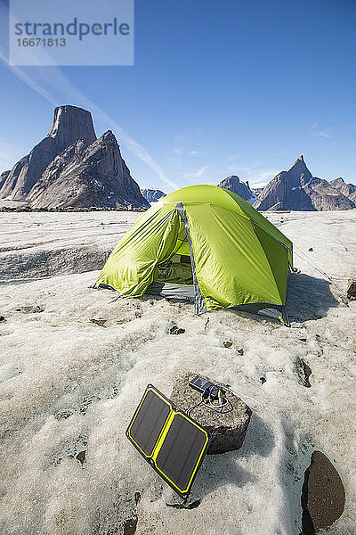 Aufladen eines Solarmoduls mit Zelt im Hintergrund auf einem abgelegenen Campingplatz