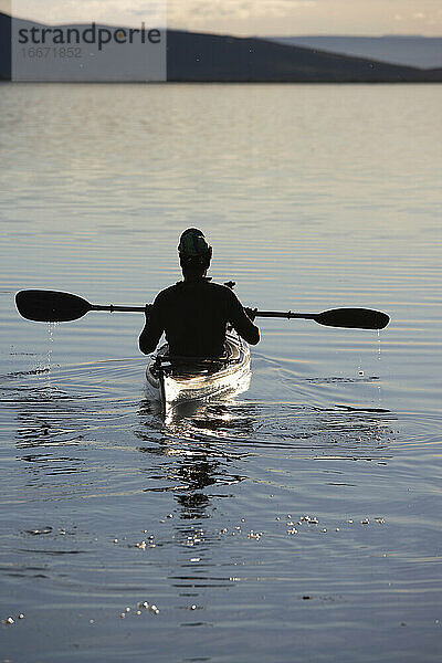 Mann genießt die Ruhe des Myvatn-Sees in seinem Seekajak