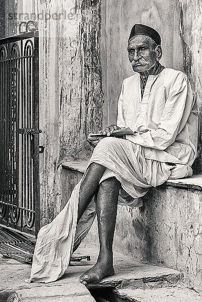 Unverfälschtes Porträt eines alten Mannes  der in den Straßen von Pushkar sitzt