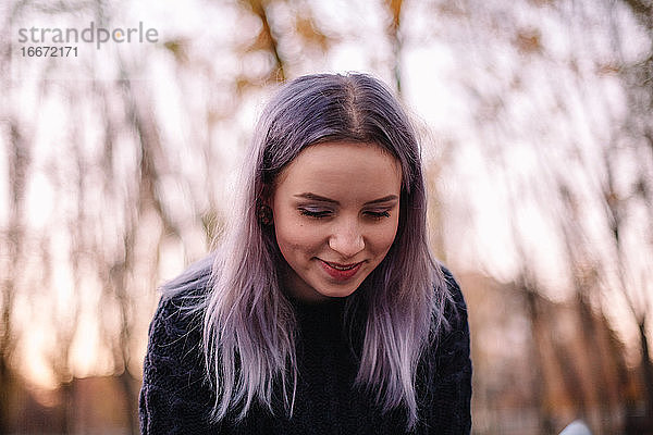 Porträt der niedlichen lächelnden Hipster junge Frau im Park im Herbst