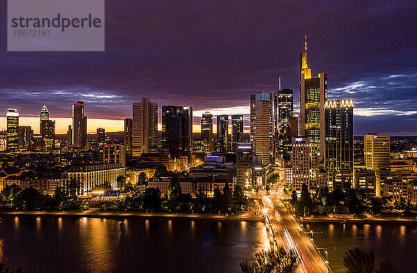 Großansicht der Skyline von Frankfurt am Main bei Nacht mit dem Main im Vordergrund und den Lichtern der Stadt