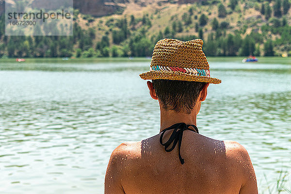 Frau mit nacktem Rücken beim Betrachten des Wassers