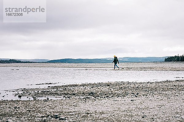 Mann  der allein am Wasser und in den Bergen in Nordschweden spazieren geht