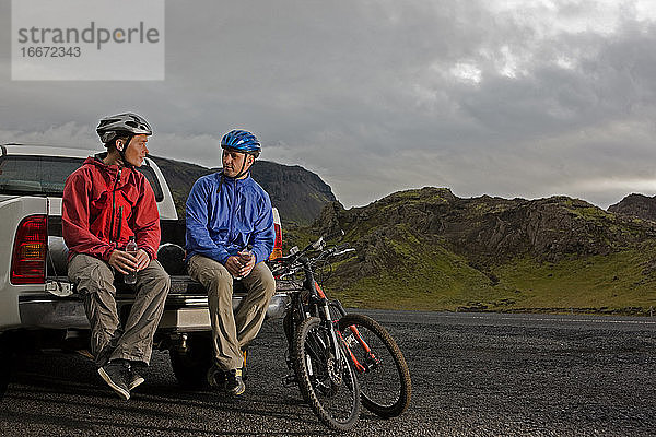 zwei Freunde fahren mit ihren Mountainbikes um den Thingvellir-See