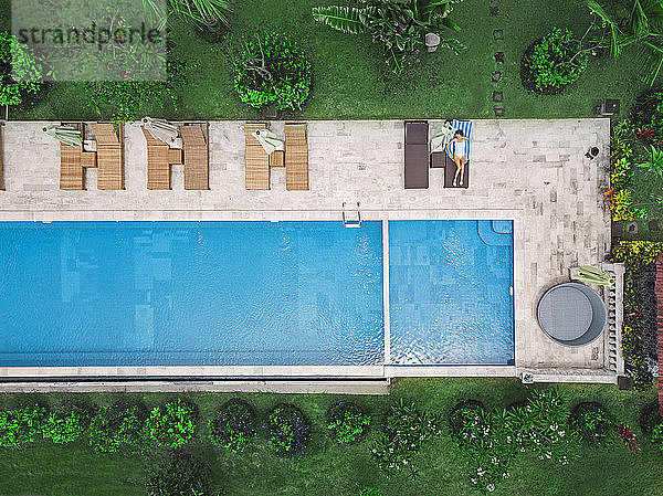 Luftaufnahme einer attraktiven Frau in der Nähe des Pools im Resort