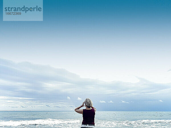attraktive blonde Frau genießt den Strand an einem bewölkten Tag