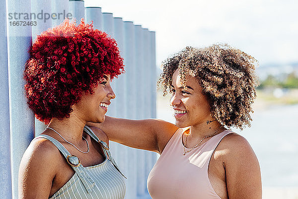 Zwei Latinos mit Afro-Haar in unbeschwerter Haltung.