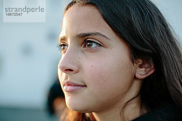 Close up Profil eines zwölfjährigen Mädchens in der Hälfte von der Sonne beleuchtet