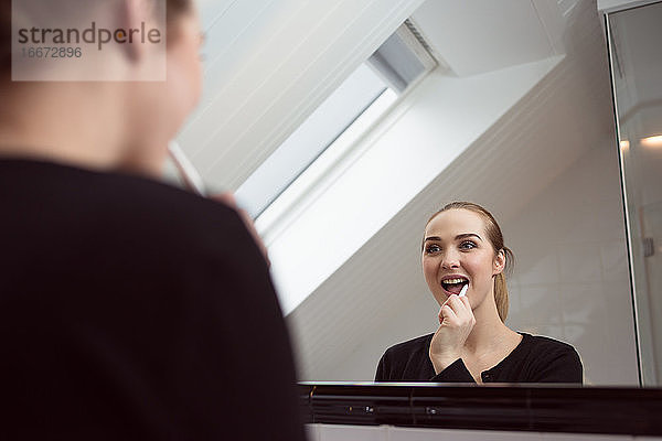 Frau beim Zähneputzen im Badezimmer