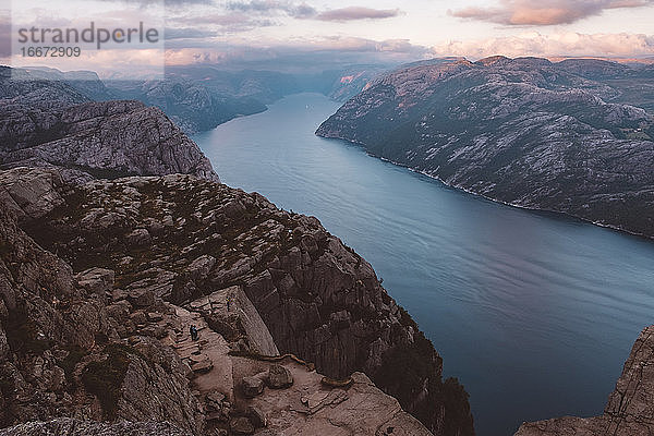 Landschaftliche Ansicht der norwegischen Fjorde  blauer Himmel  unerkennbares Paar in den Felsen stehend