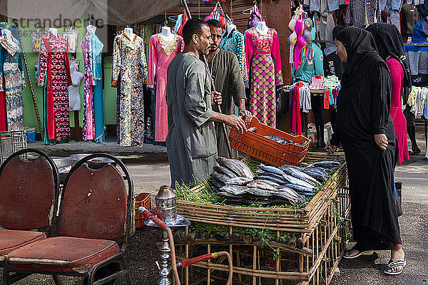 Frau kauft Fisch von einem Straßenhändler