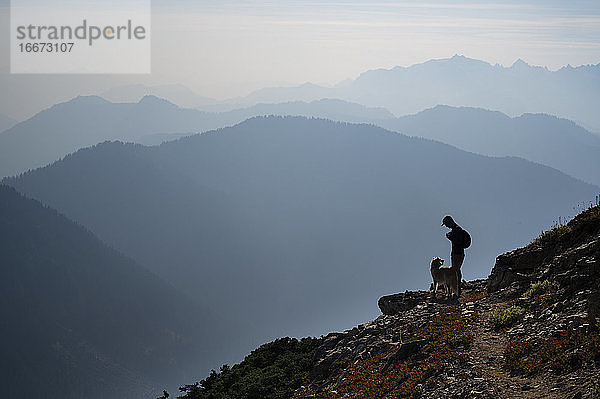 Wildfire Smoke Berg Schichten mit Silhouette Wanderer und Hund