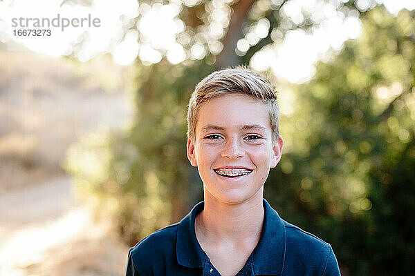 Lächelndes Porträt eines jungen Teenagers mit Zahnspange